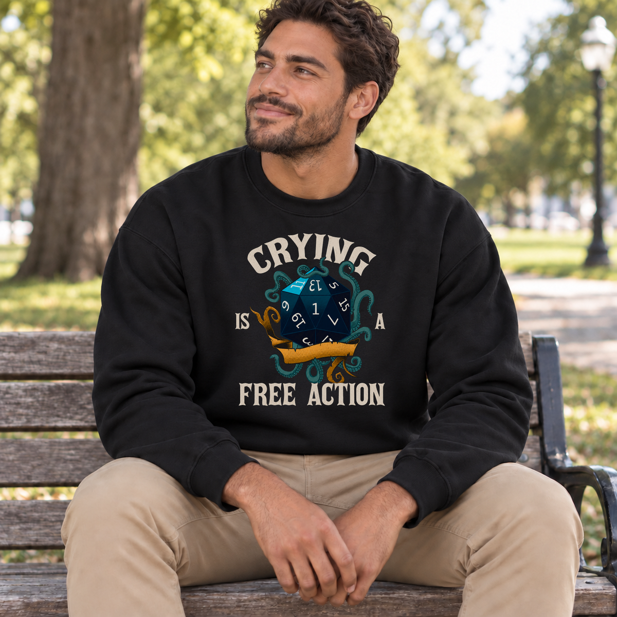 Crying Is a Free Action black DnD sweatshirt worn by a man in a park