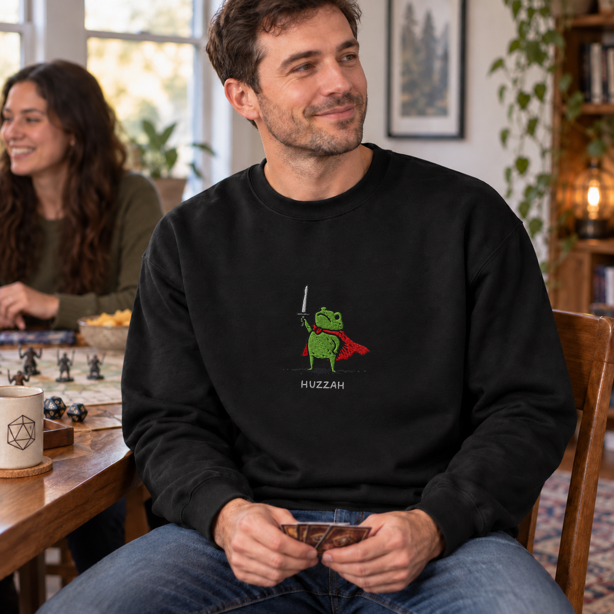 Huzzah Frog Knight black DnD sweatshirt worn by a man at game night