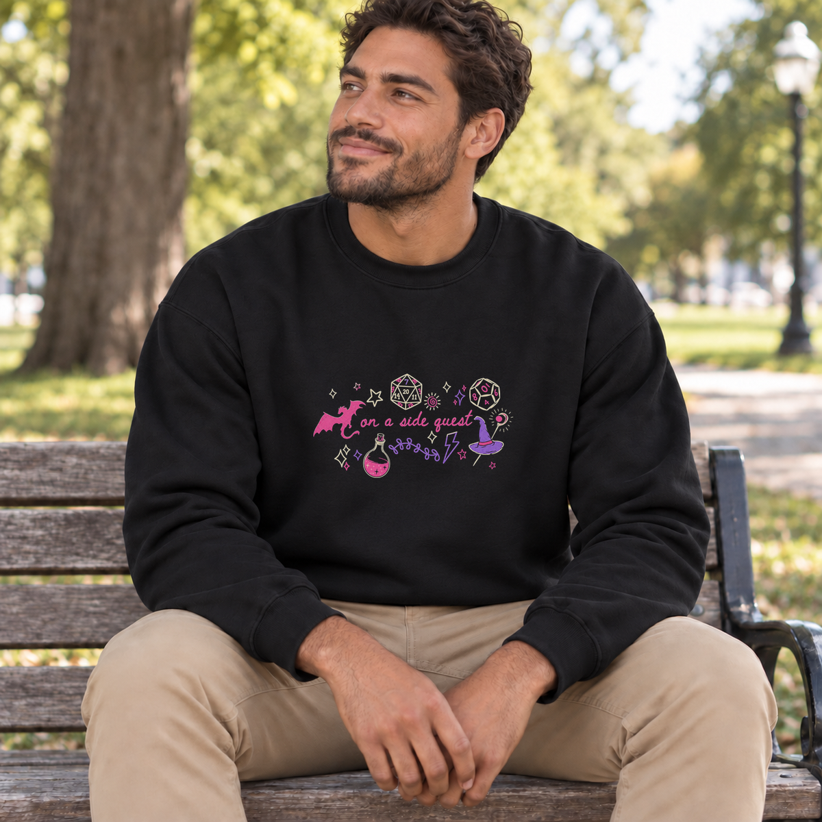 On a Side Quest black DnD sweatshirt worn by a man in a park