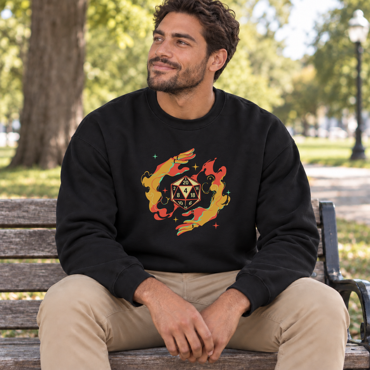 Flaming D20 black DnD sweatshirt worn by a man in a park