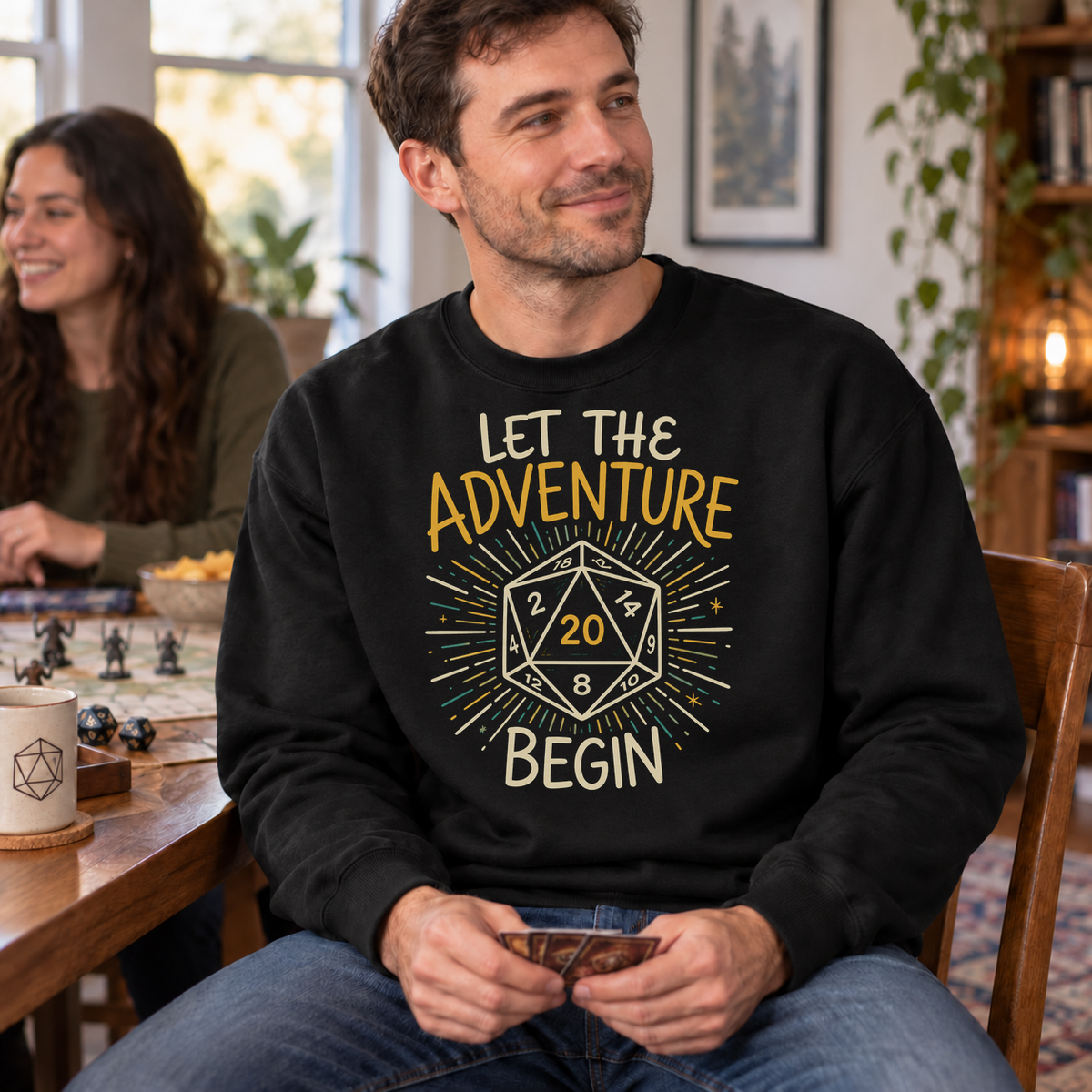 Let the Adventure Begin black DnD sweatshirt worn by a man at game night
