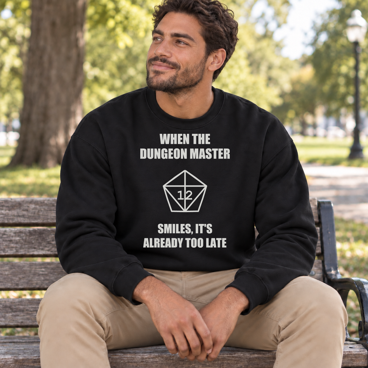 The Dungeon Master Smiles black DnD sweatshirt worn by a man in a park